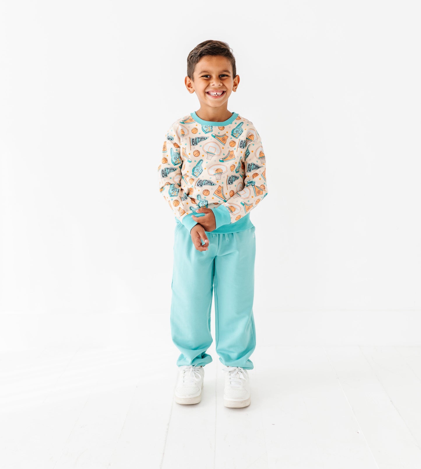 Child wearing a bamboo basketball sweater and light blue pants on a white background