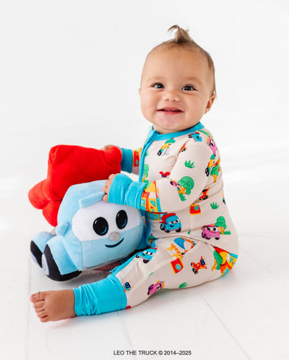 Baby wearing a colorful Leo the Truck bamboo outfit with a soft Leo the Truck toy on a white background