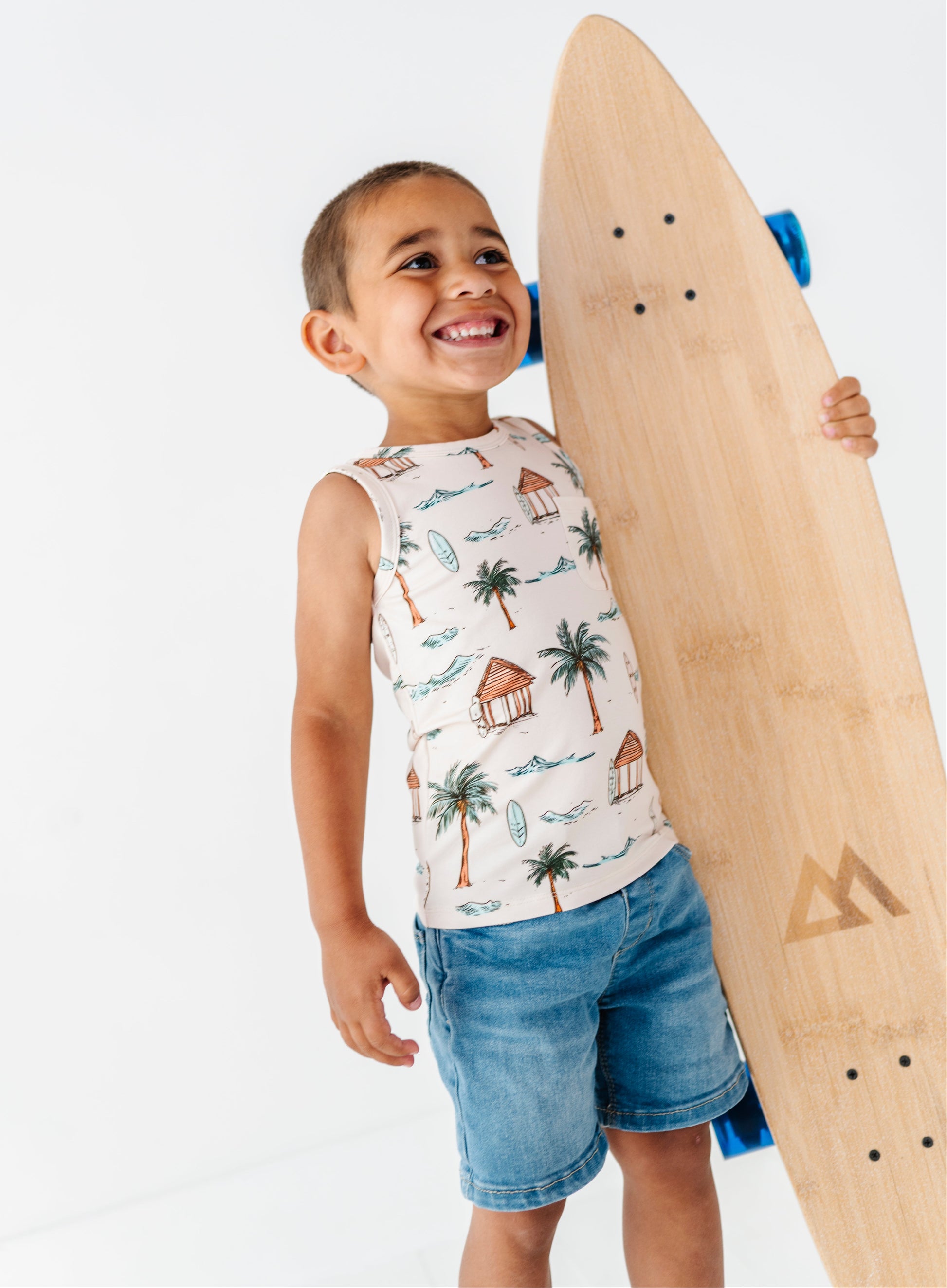 Child holding a wooden skateboard with a white background