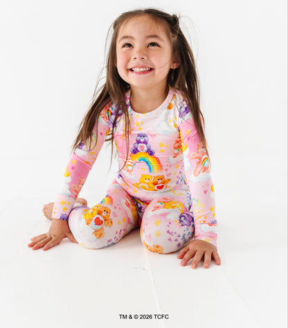 Child wearing a colorful outfit with rainbow and bear designs on a white background