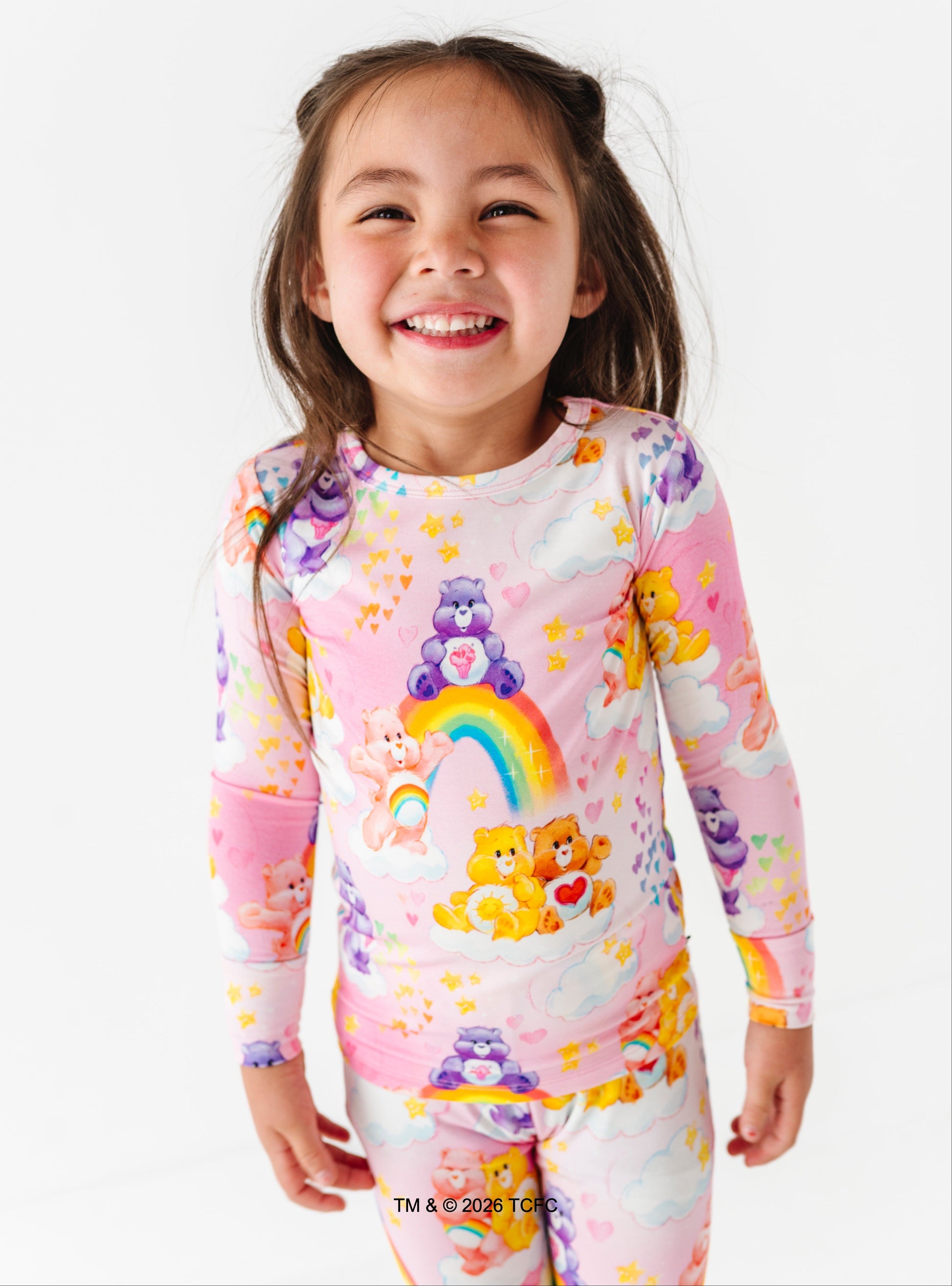 Child wearing a colorful onesie with cartoon characters on a white background