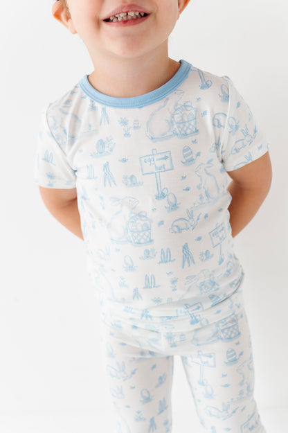 Child wearing a white bamboo Easter pajama set with blue patterns on a white background