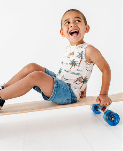 Child sitting on a skateboard with blue wheels on a white background