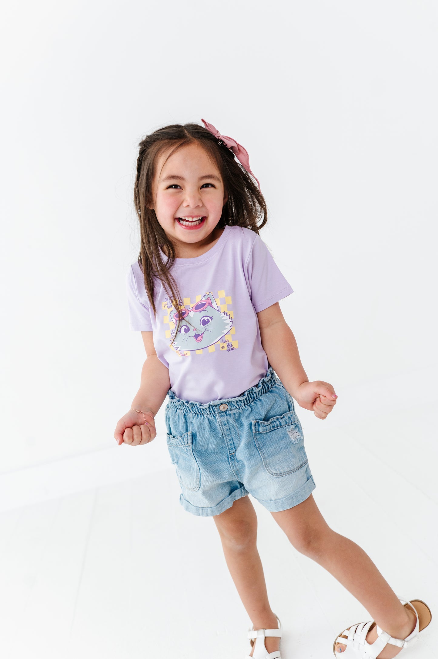 Child wearing an officially licensed 44 Cats t-shirt and denim shorts on a white background