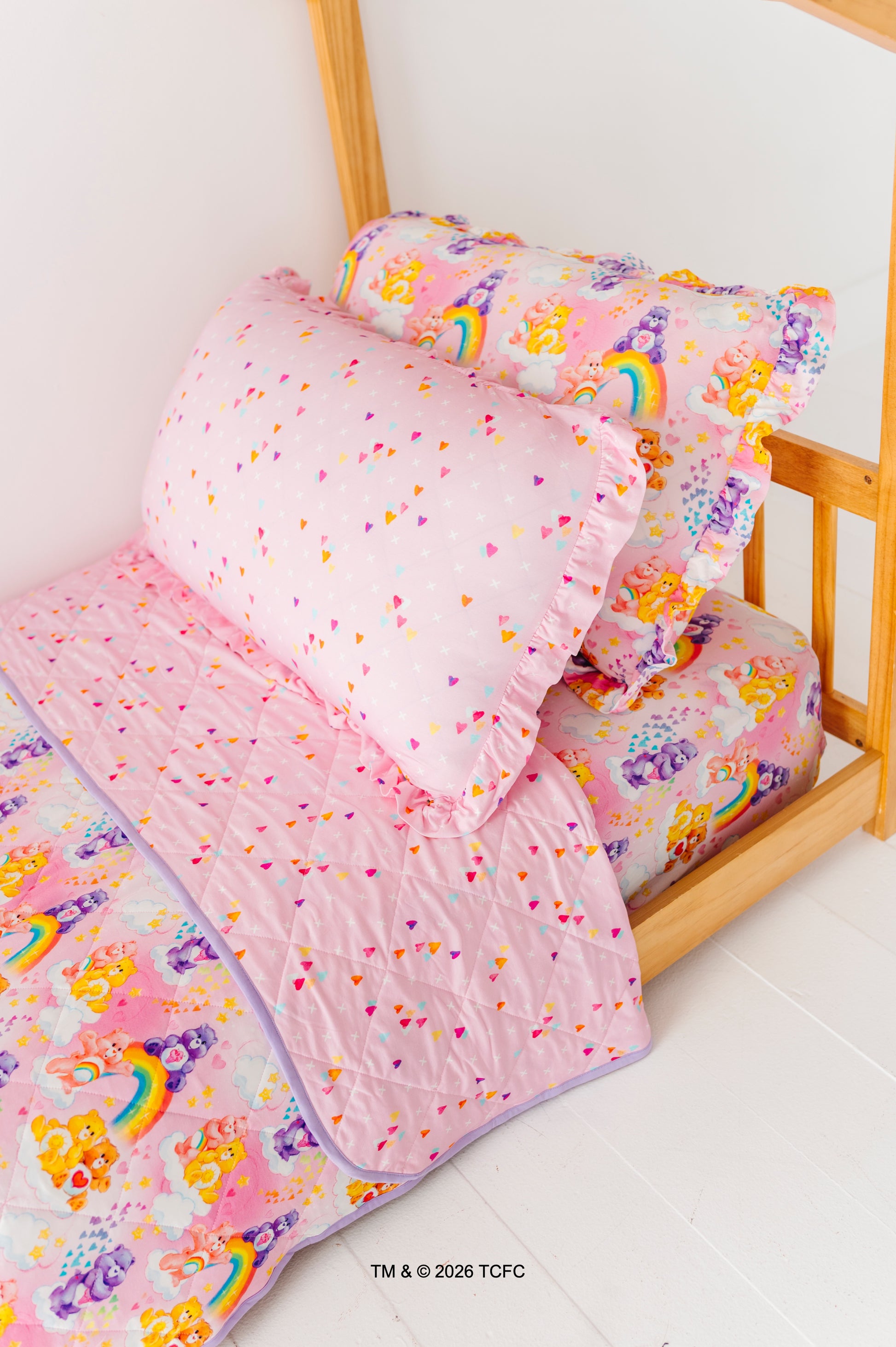 Children's bed with Care Bears™ bedding featuring sheets, pillowcases, and quilted blanket