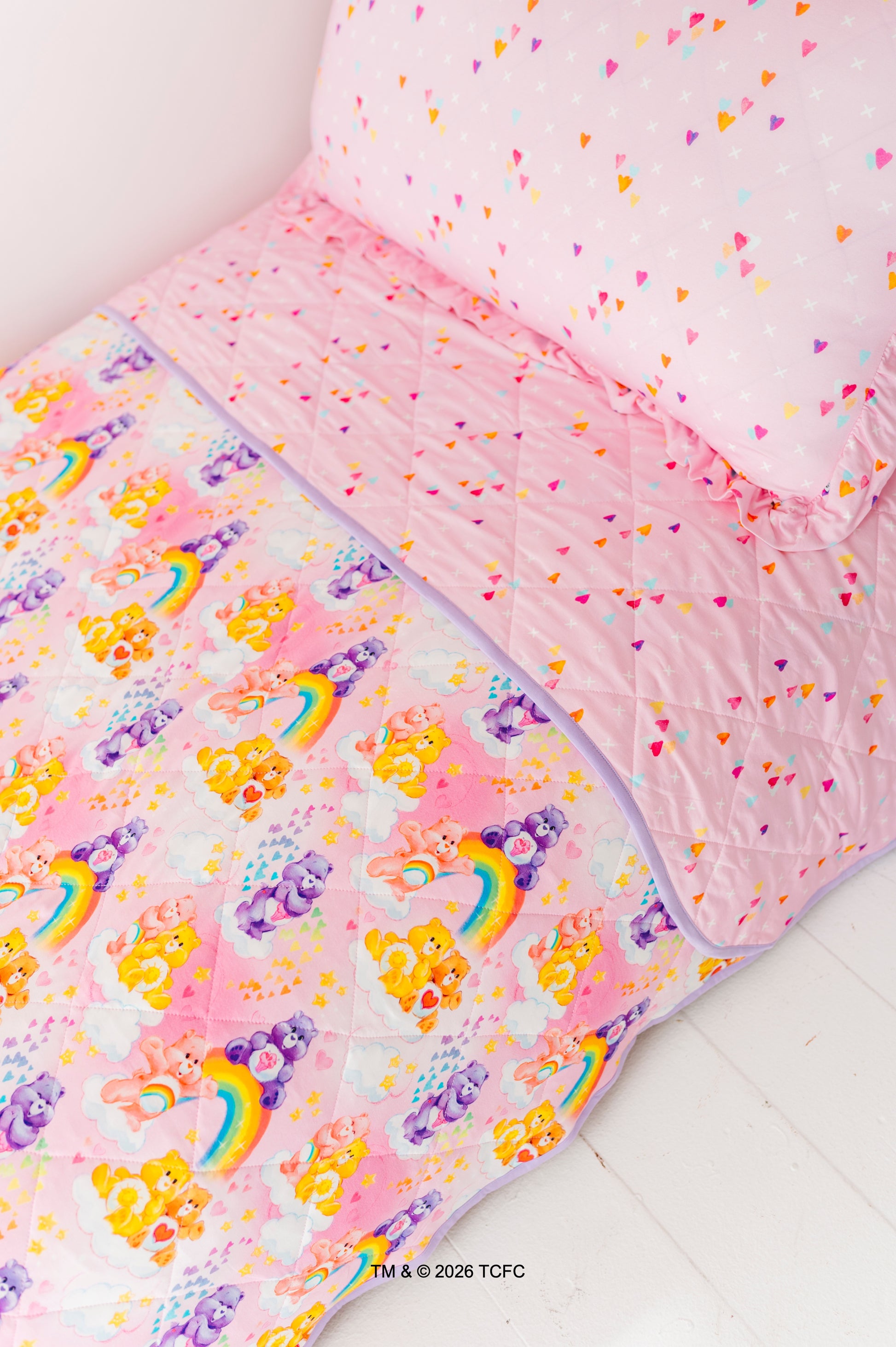 Children's bedding set with rainbow and Care Bears™ pattern on a white background