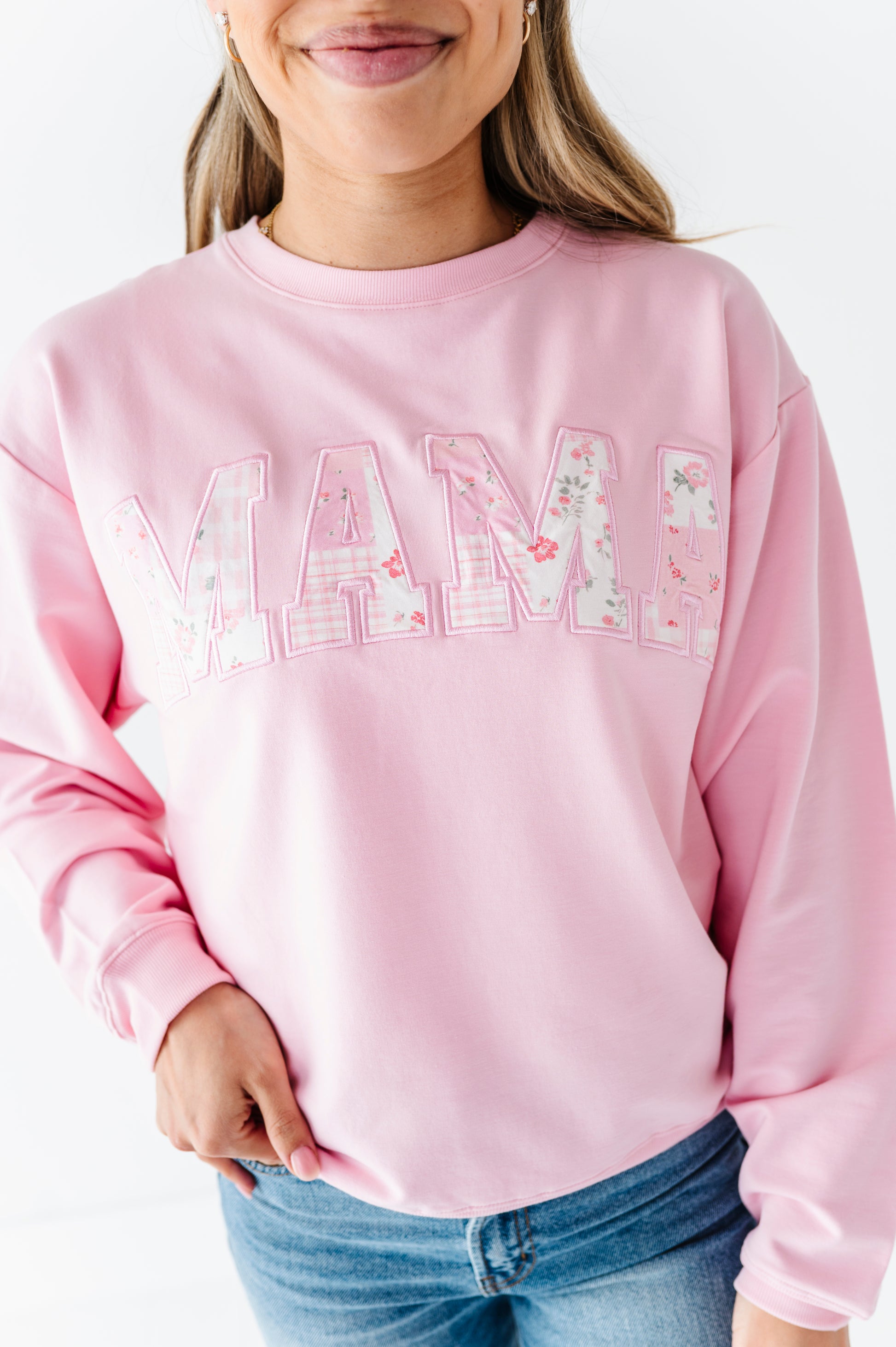Mom wearing a pink bamboo/cotton sweatshirt with 'MAMA' printed on it against a white background
