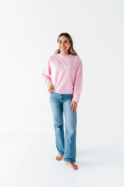 Woman wearing a pink bamboo sweatshirt and blue jeans on a white background