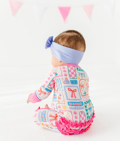 Baby wearing a colorful Geese-patterned romper with ruffles on a white background