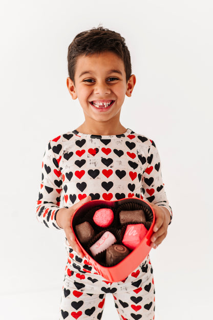 Smiling child wearing King of Hearts bamboo pajamas during Valentine’s themed photoshoot