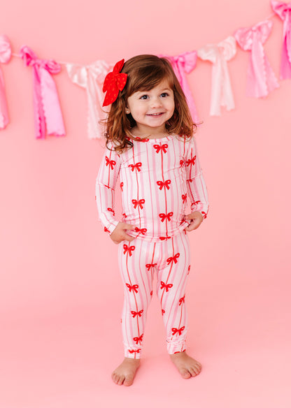 Child in Ruby Ribbons bamboo pajamas with red bows and pink stripes