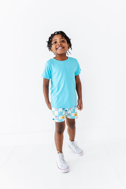 Child wearing a light blue t-shirt and 44 Cats shorts on a white background