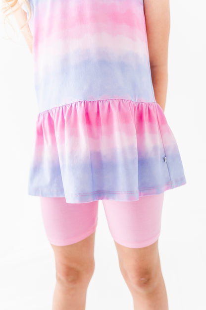 Pastel tie-dye bamboo-cotton peplum top with pink bamboo biker shorts on a white background