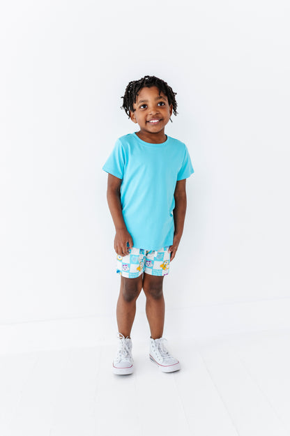 Child wearing a light blue t-shirt and officially licensed 44 Cats shorts on a white background