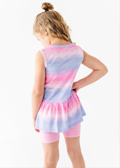 Young girl wearing a tie-dye bamboo top and shorts on a white background