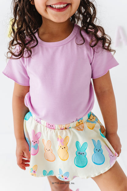 Child wearing a purple shirt and PEEPS®-themed skirt on a white background