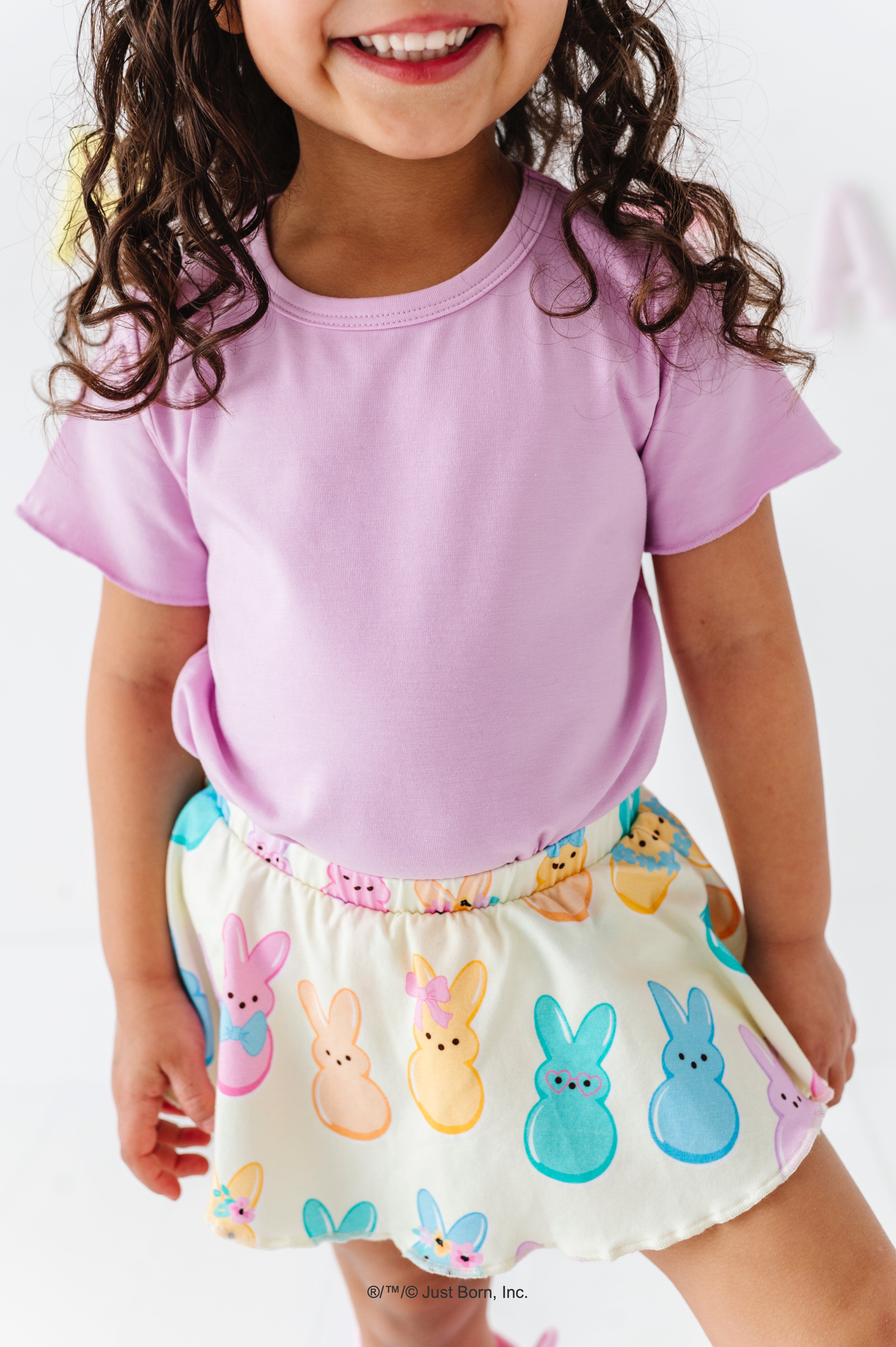 Child wearing a lavender lettuce hem bamboo blend shirt and PEEPS®-themed skirt on a white background