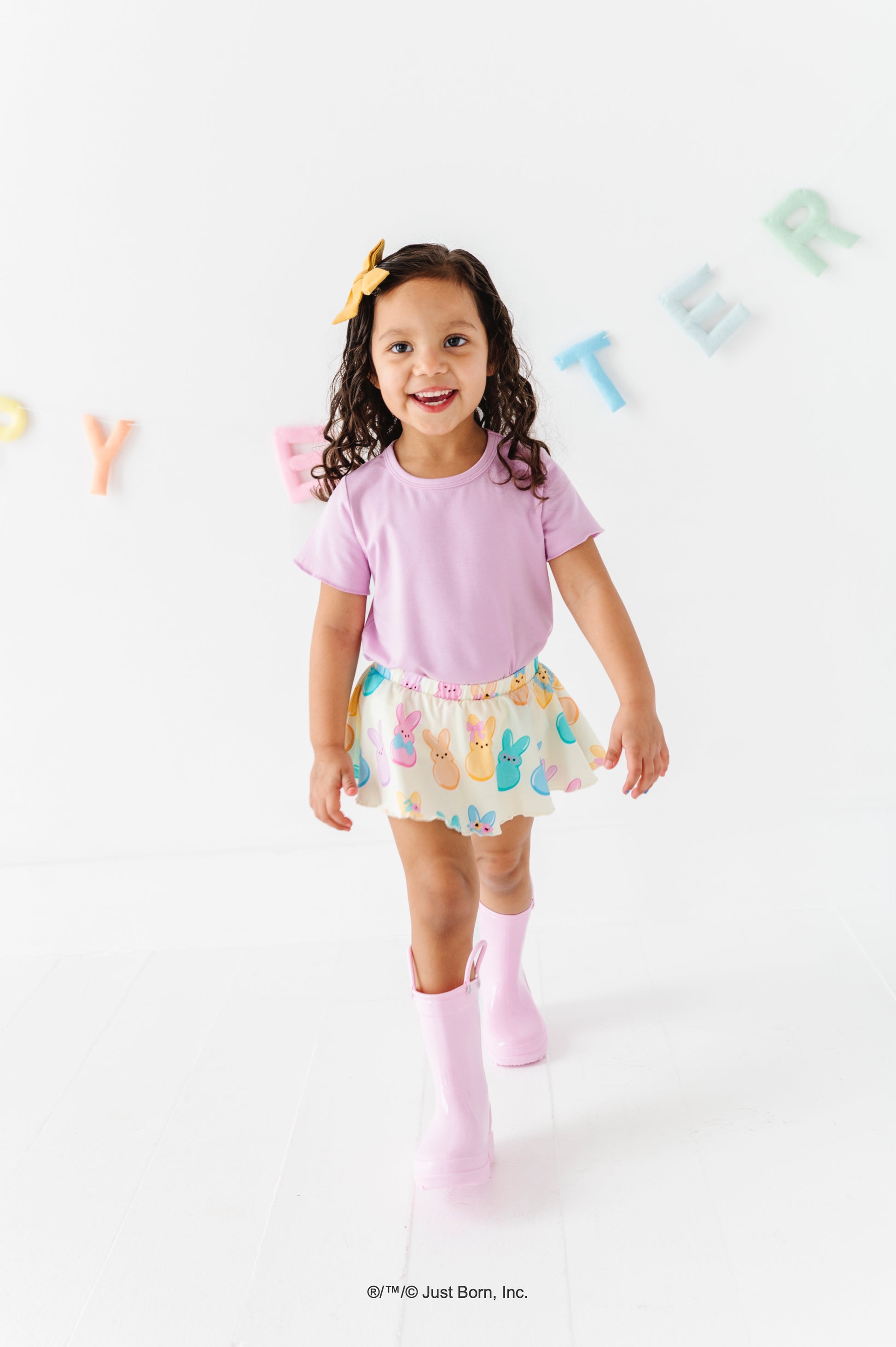 Child wearing a lavender bamboo blend shirt and colorful PEEPS® skort with a white background