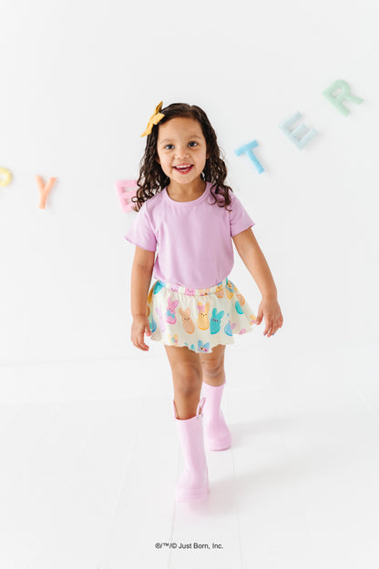 Child wearing a lavender bamboo blend shirt and colorful PEEPS® skort with a white background