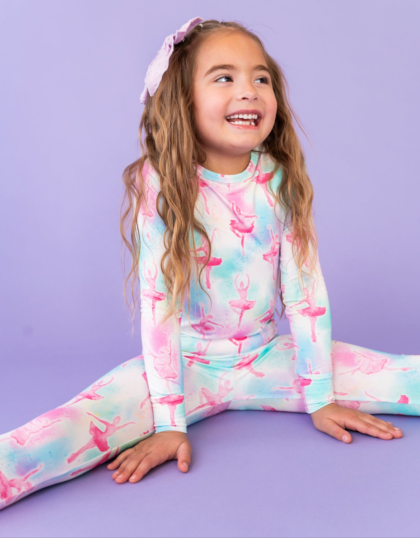 Young girl wearing a colorful ballet-themed outfit on a purple background