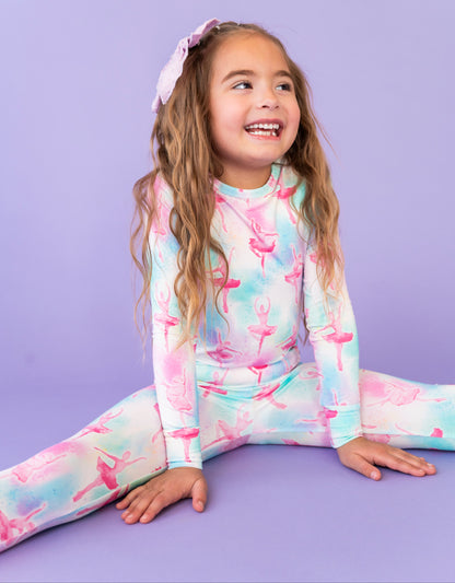 Young girl wearing a colorful ballet-themed outfit on a purple background