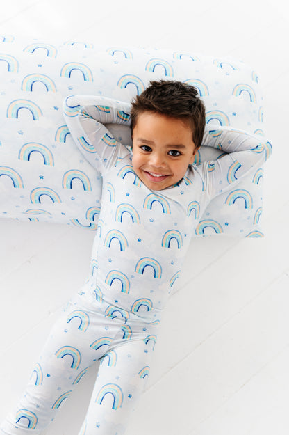 Child wearing a bamboo two-piece set with rainbow patterns on a white background