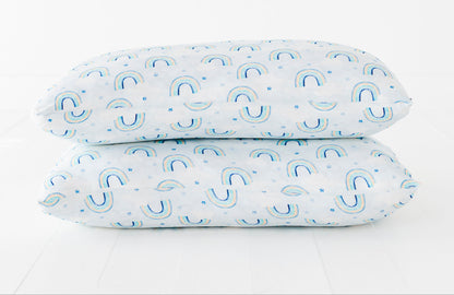 Two bamboo pillowcases with a blue watercolor rainbow pattern on a white background