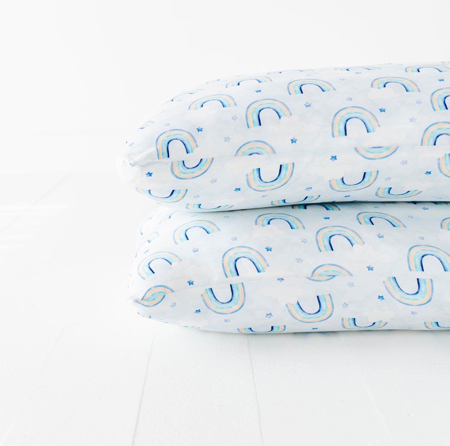 A bamboo pillowcase set with blue watercolor rainbow pattern on a white background