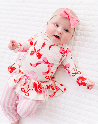 Baby wearing Blushing Bows peplum top with ruffled hem and soft stretch fabric