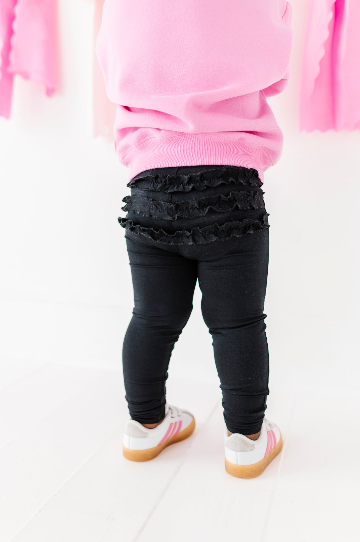 Toddler wearing black leggings with ruffle detail on the back