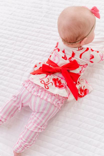 Back view of Blushing Bows peplum top showing statement red bow detail