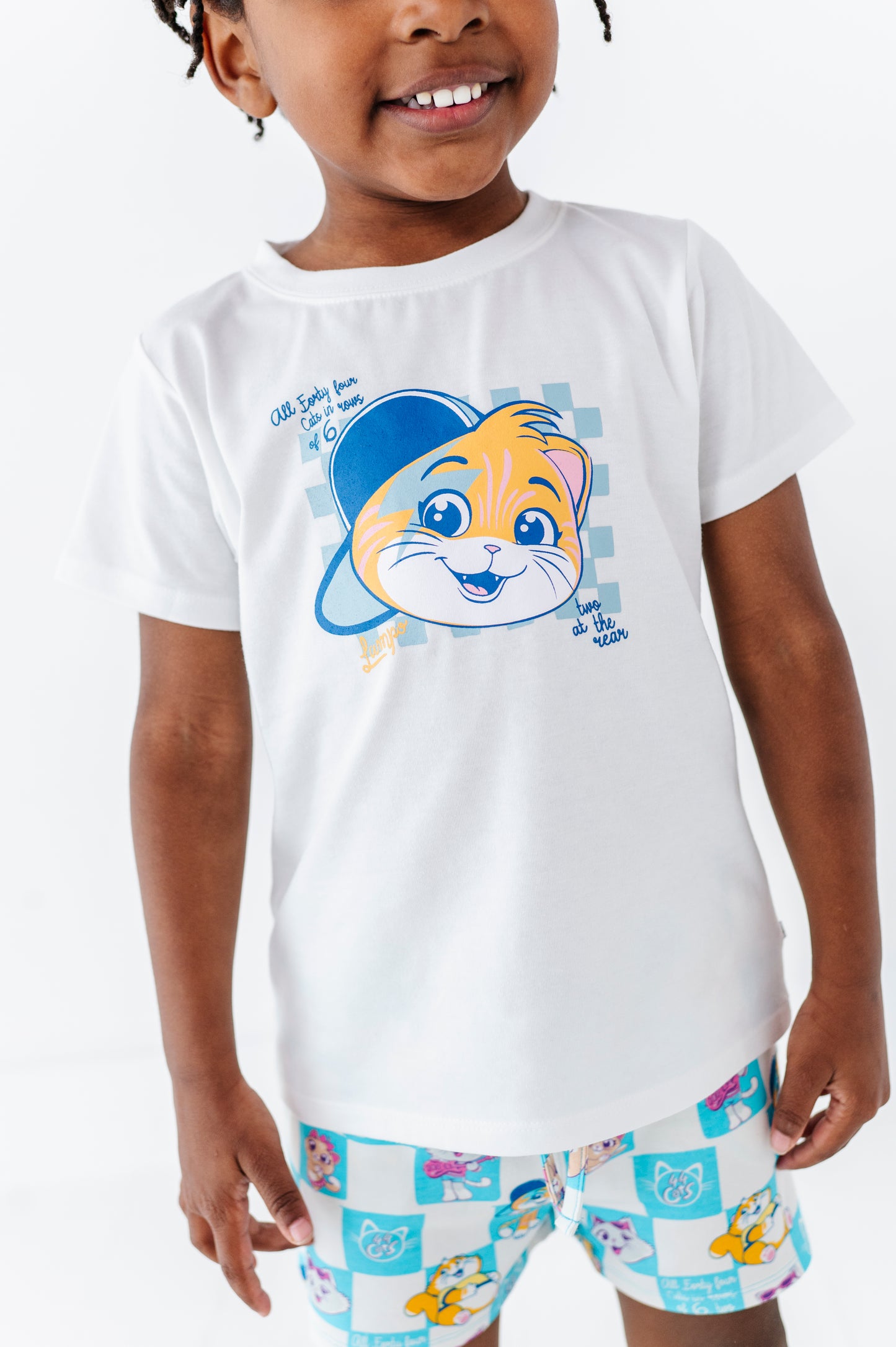 Child wearing a white t-shirt with a cartoon character (44 Cats) and matching bamboo blend shorts on a white background