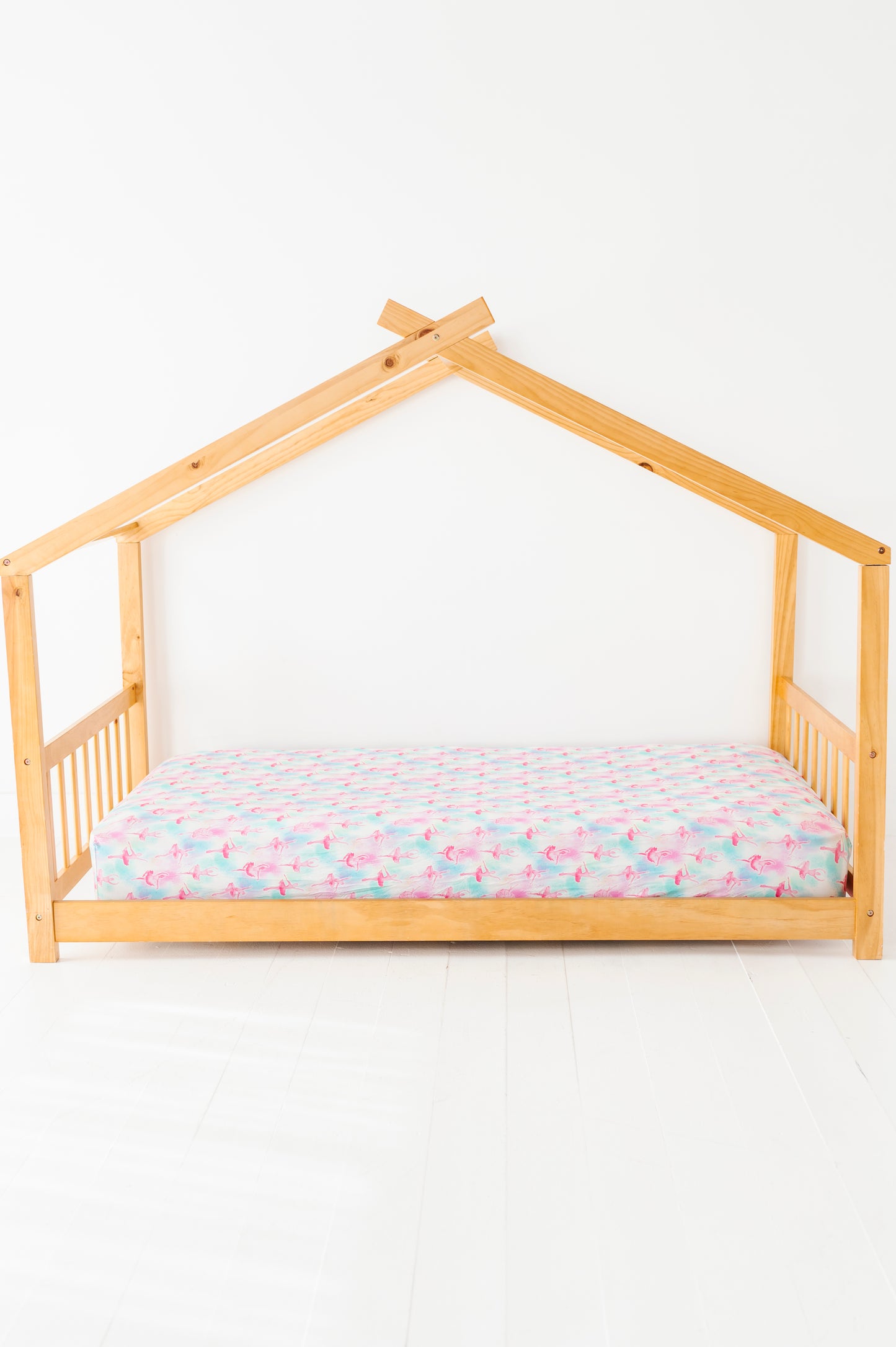 Wooden house-shaped bed with twin-size bamboo sheets featuring watercolor ballerinas 