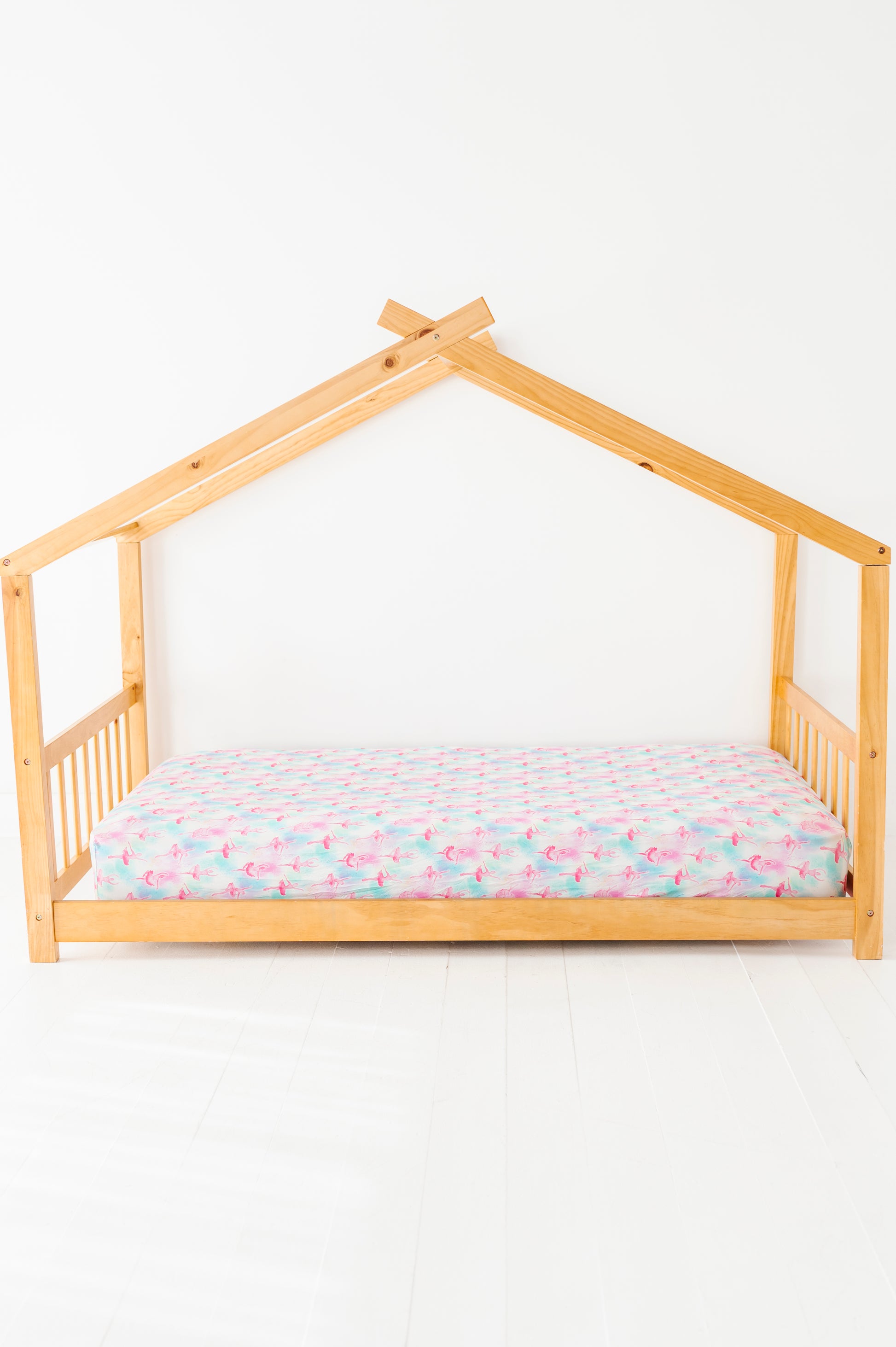 Wooden house-shaped bed with twin-size bamboo sheets featuring watercolor ballerinas 