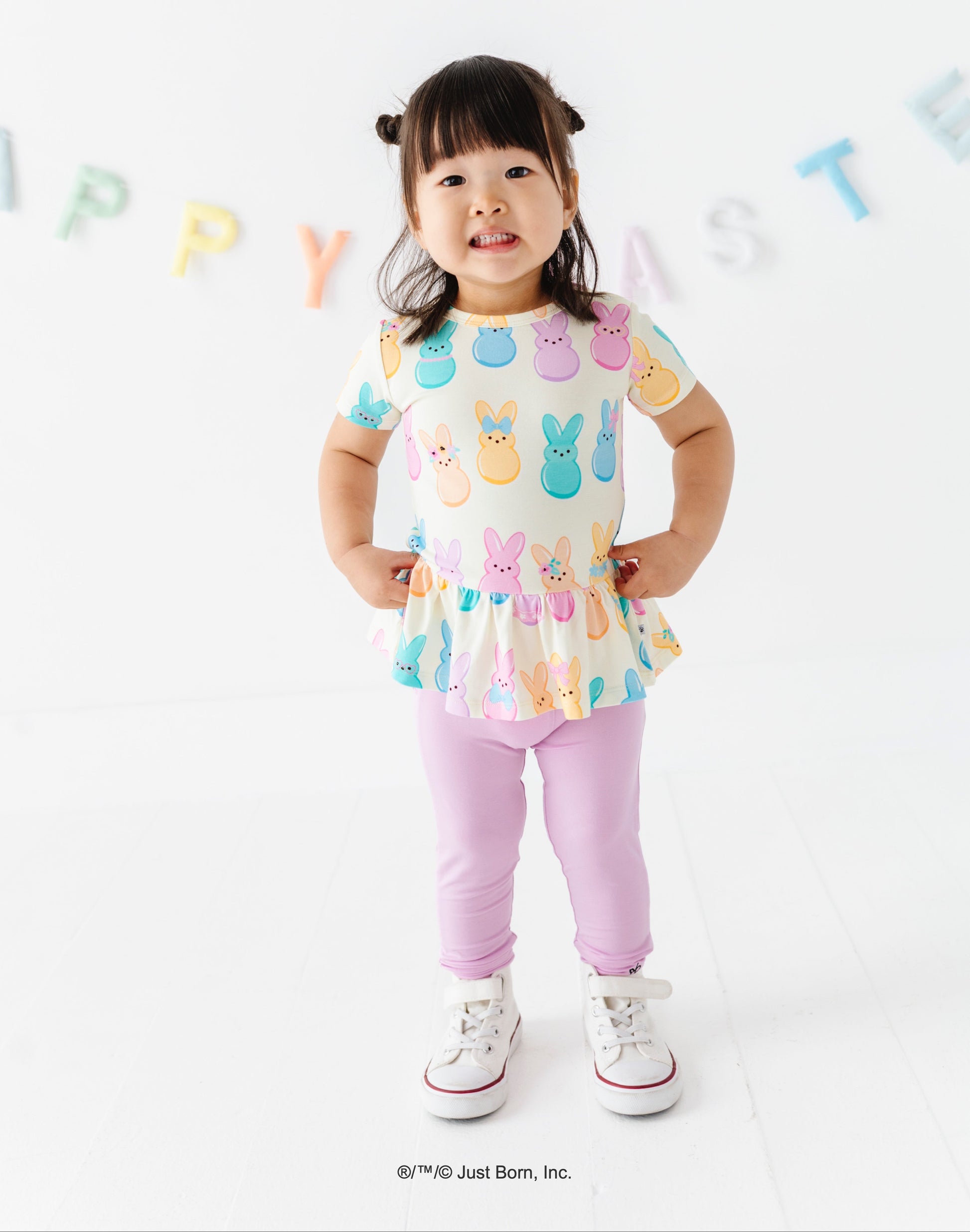 Child wearing a colorful top with PEEPS® bunny designs on a white background