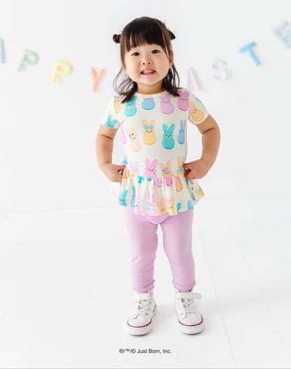 Child wearing a colorful top with PEEPS® bunny designs on a white background