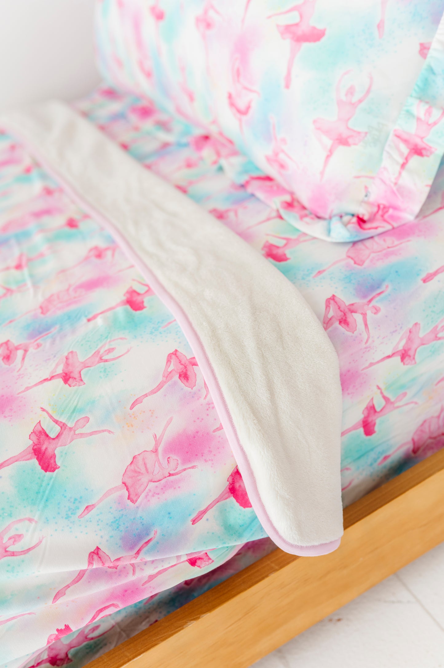 Bamboo bedding set with colorful ballerina pattern on a bed.