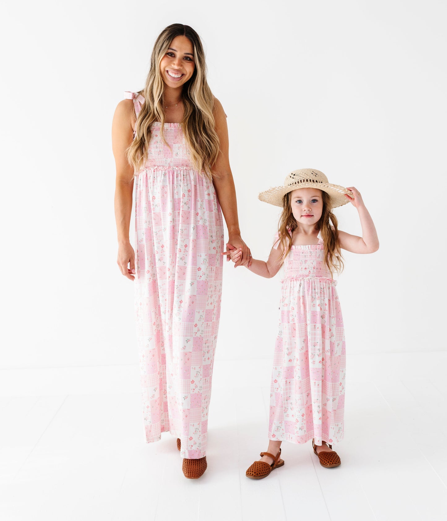 Woman and young girl wearing matching pink floral bamboo maxi dresses on a white background