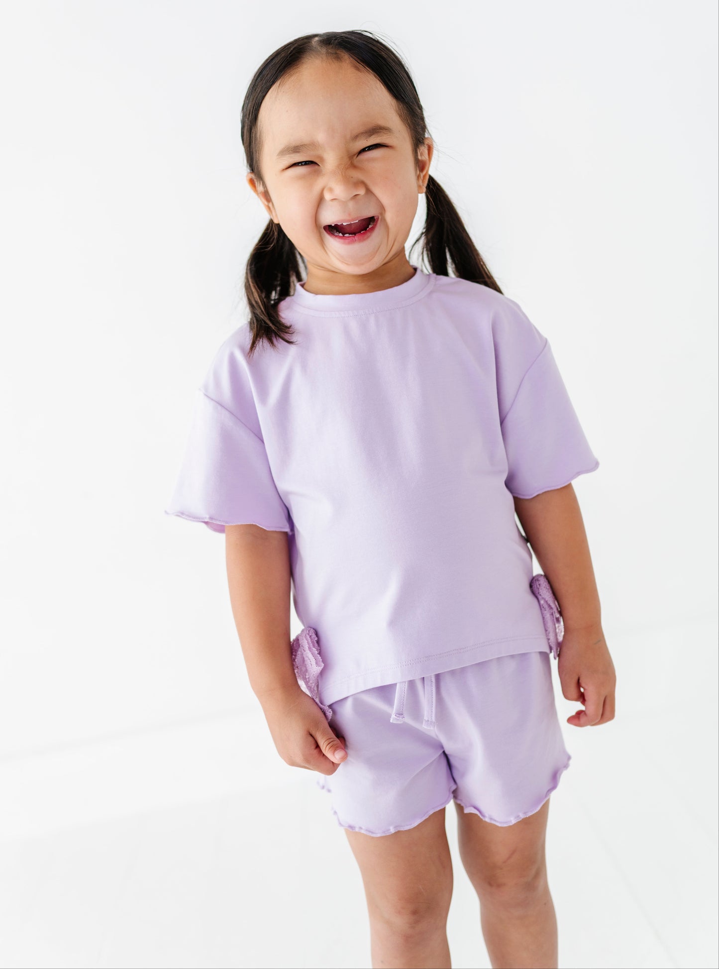 Child wearing a light purple outfit on a white background
