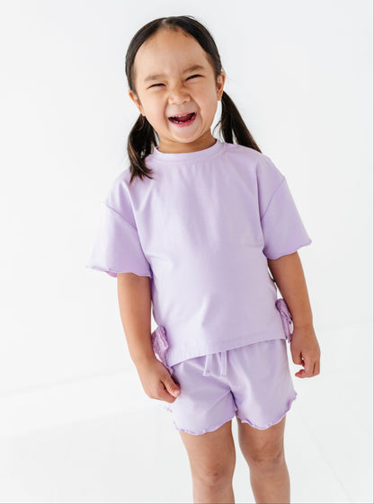 Child wearing a light purple outfit on a white background