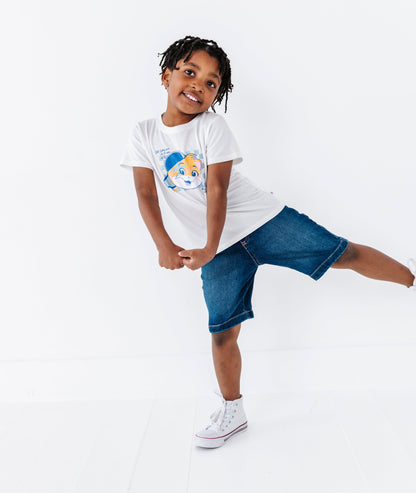 Child wearing a white t-shirt with a graphic of Lampo from 44 Cats and denim shorts on a white background