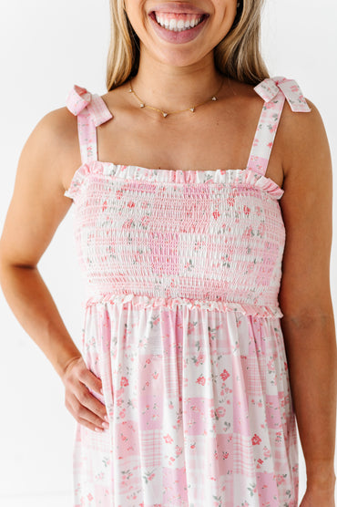 Woman wearing a pink floral bamboo maxi dress with tie straps on a white background