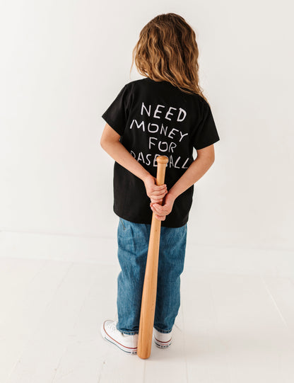 Child wearing a black t-shirt with text holding a baseball bat on a white background
