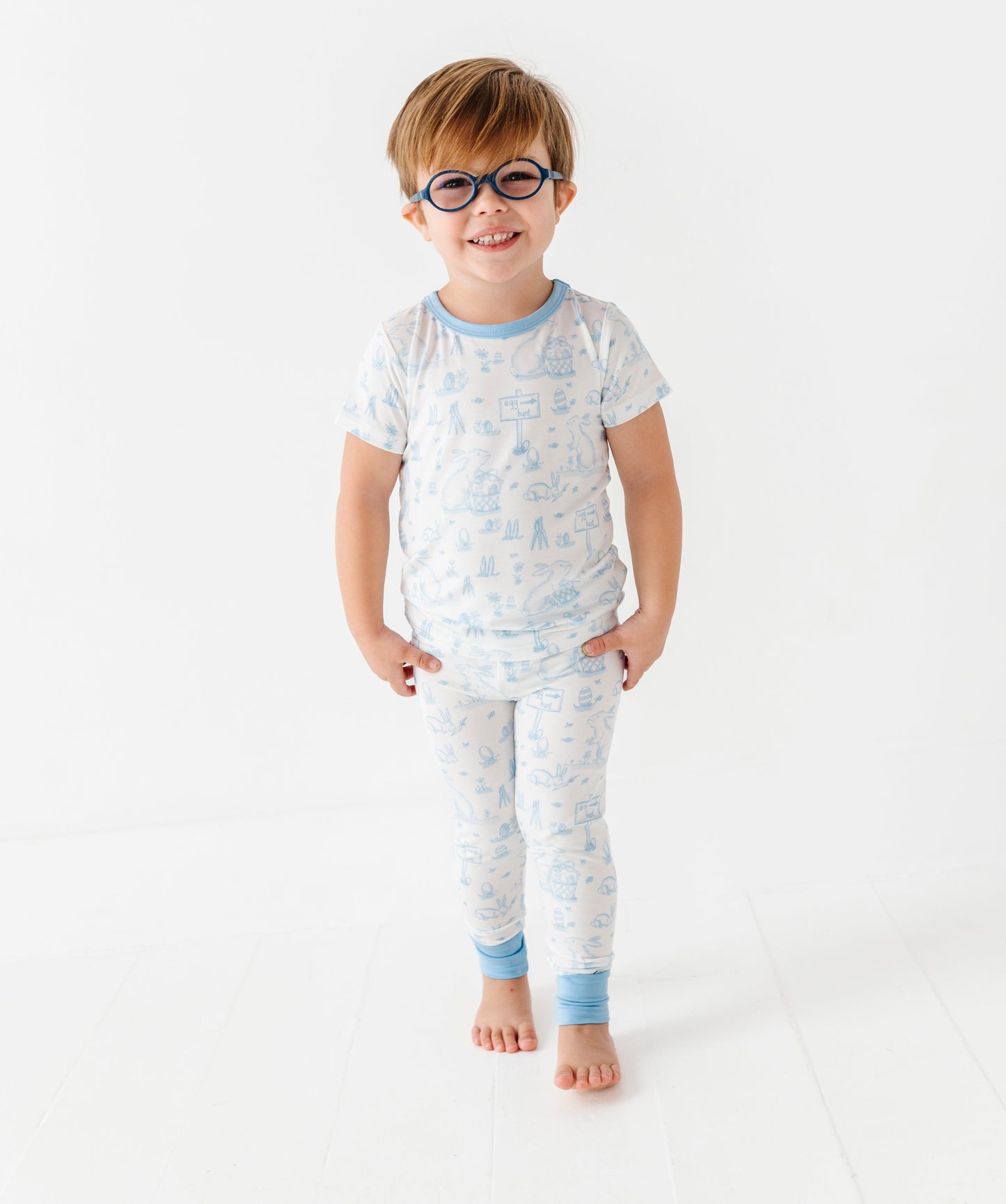 Child wearing a patterned pajama set on a white background