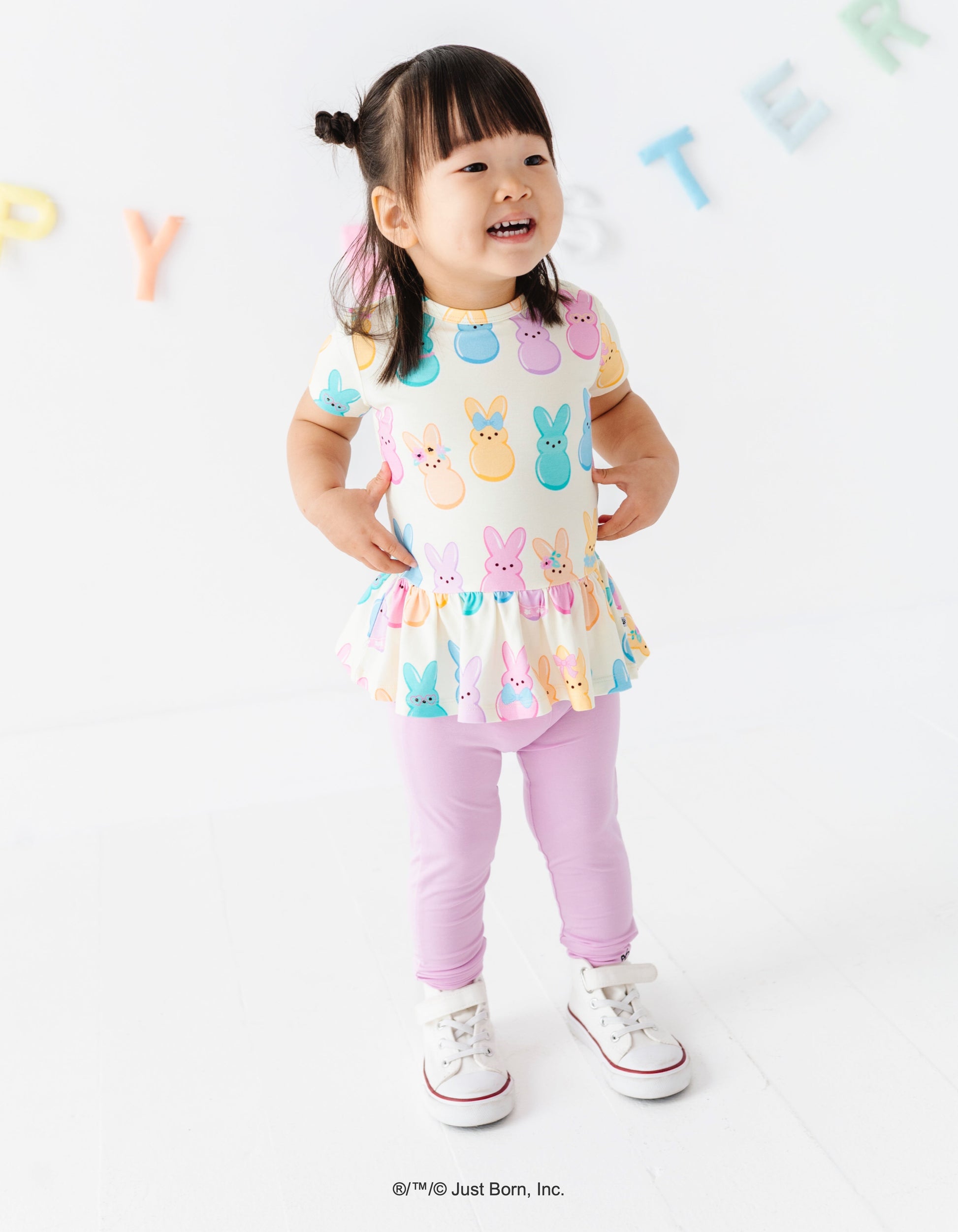 Child wearing a colorful top with PEEPS® characters on a white background
