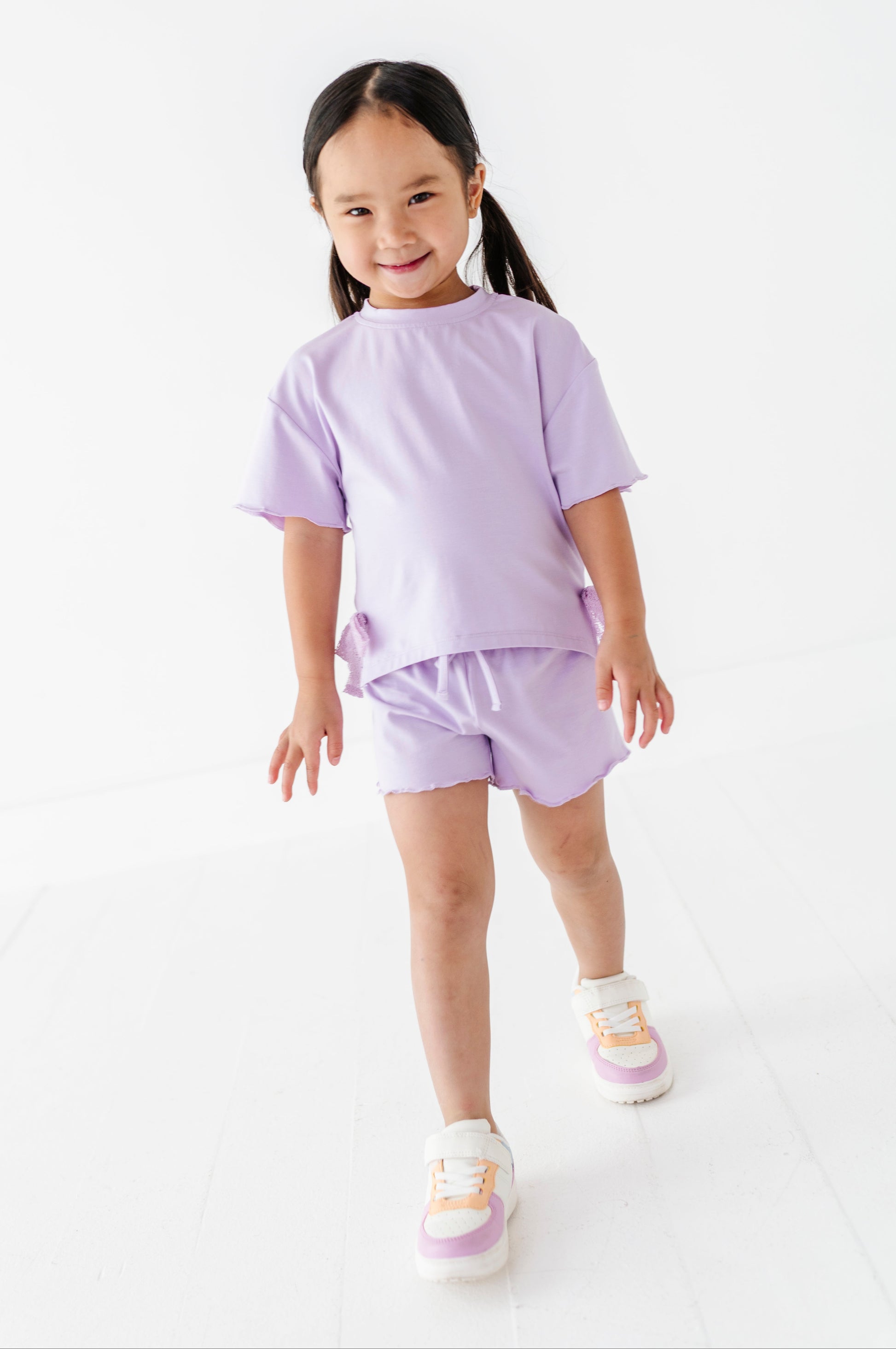 Young girl wearing a purple outfit on a white background
