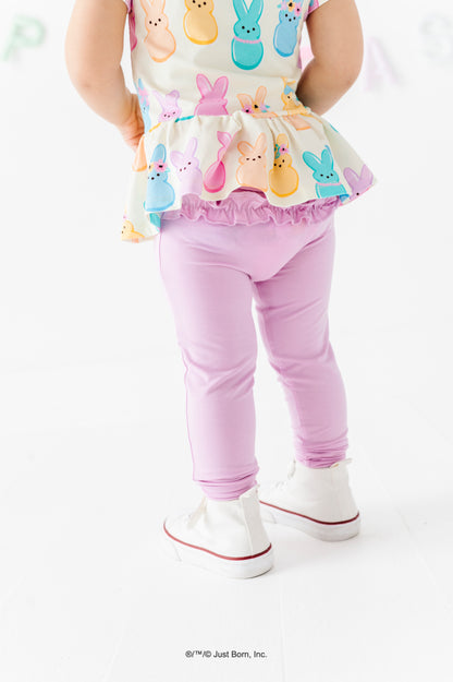 Child wearing a colorful PEEPS® top and lavender leggings on a white background