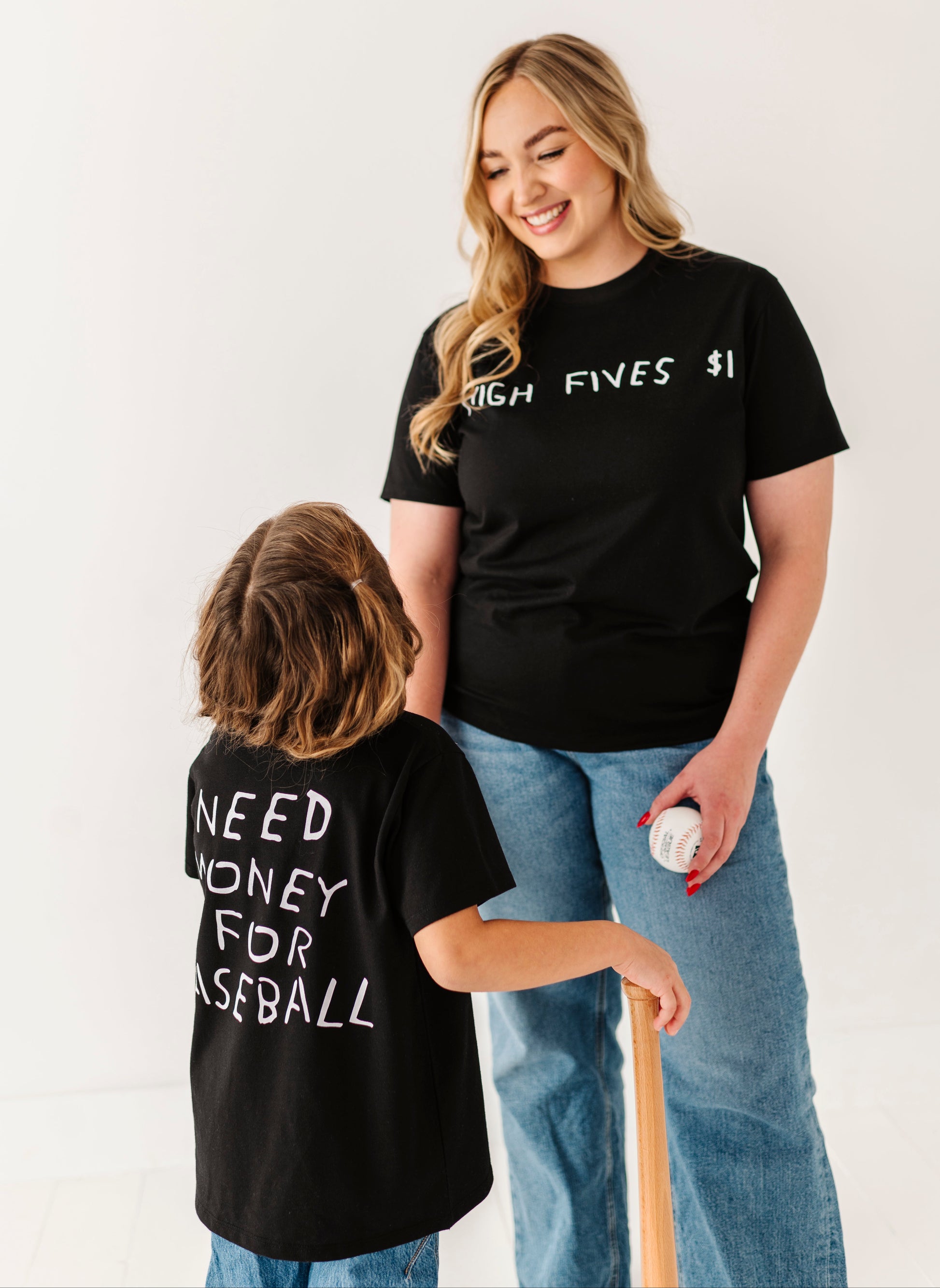 Two people wearing black t-shirts with text, standing against a white background.