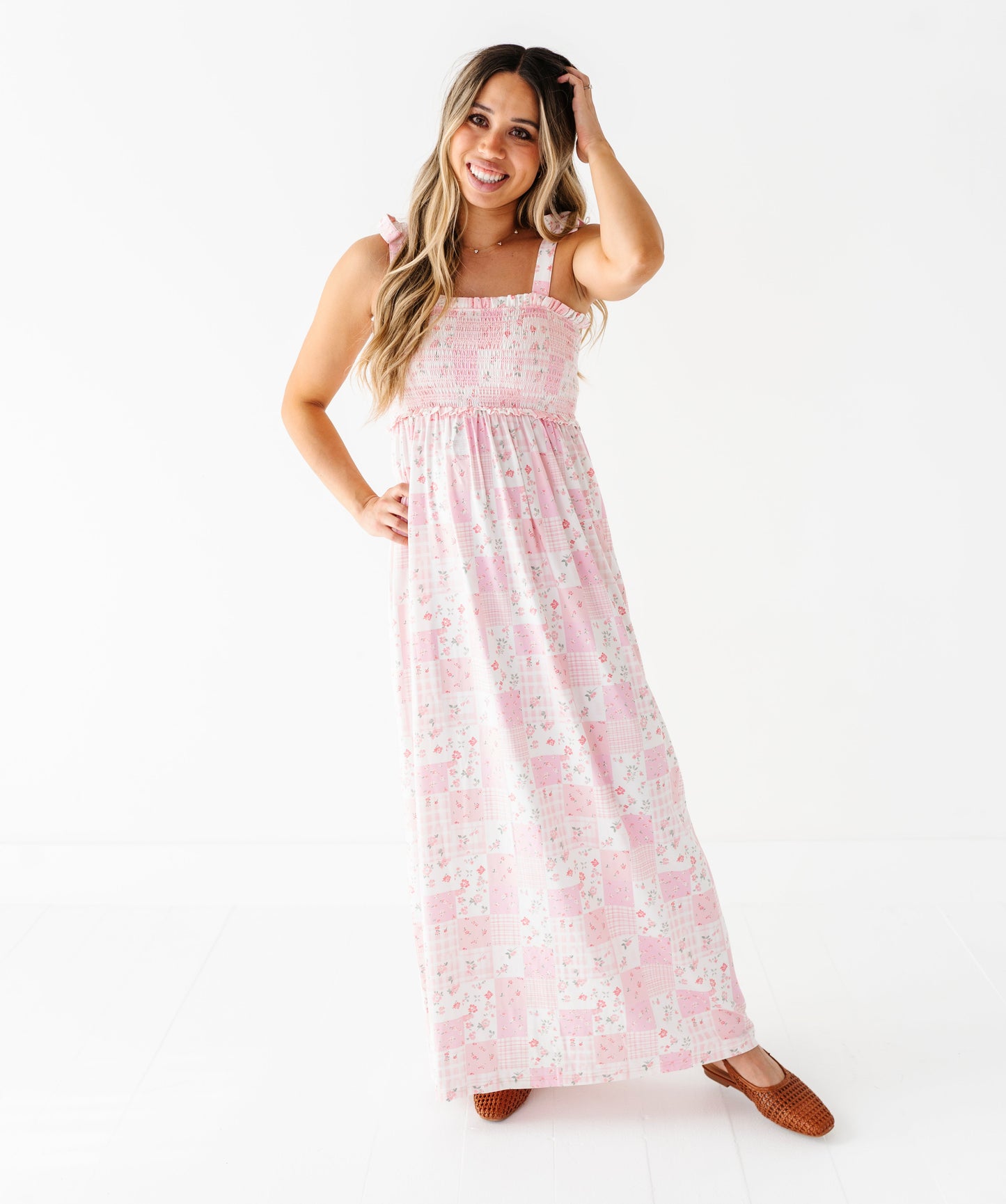 Woman wearing a pink floral bamboo maxi dress on a white background