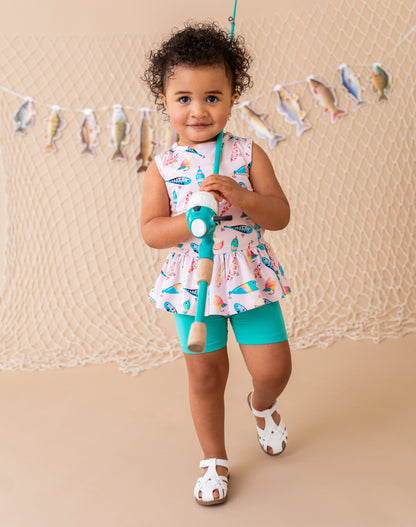 Child holding a fishing rod with a fish-themed backdrop